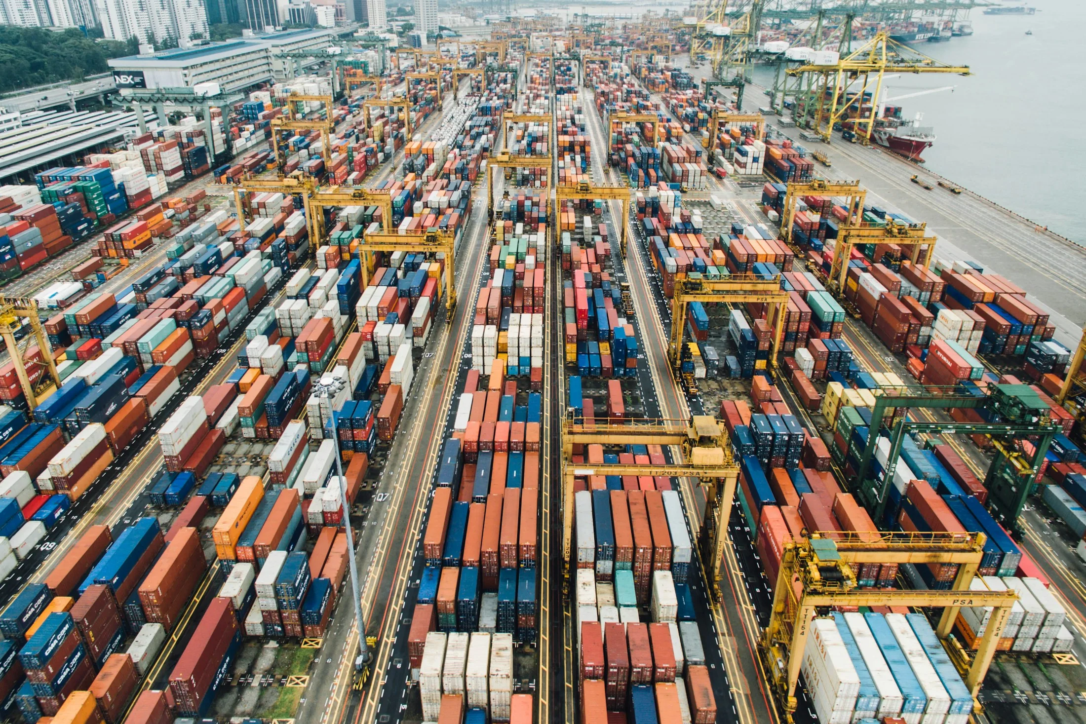 Aerial view of a container terminal with rows of cargo and gantry cranes